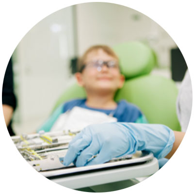 Out of focus image of a child sitting in a dentist chair wearing transparent glasses